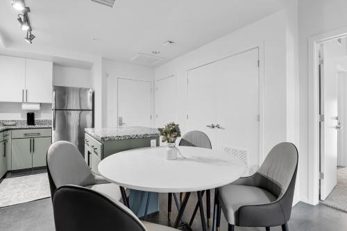 a white kitchen with a white table and chairs at The Nomad Roosevelt in Phoenix