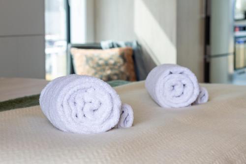 two rolled up towels on top of a bed at Upper Studio Perfection: 8 Wilmer St. Gem in Christchurch
