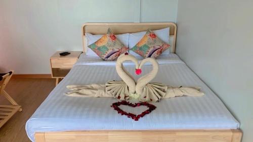 a bed with two swans making a heart gesture at Amanda อามันดา in Ban Pak Ba Ra