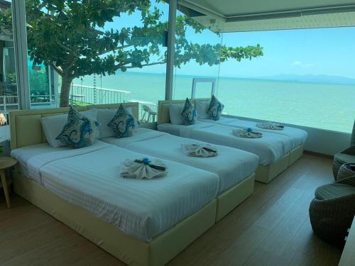 two beds in a room with a view of the ocean at Amanda อามันดา in Ban Pak Ba Ra