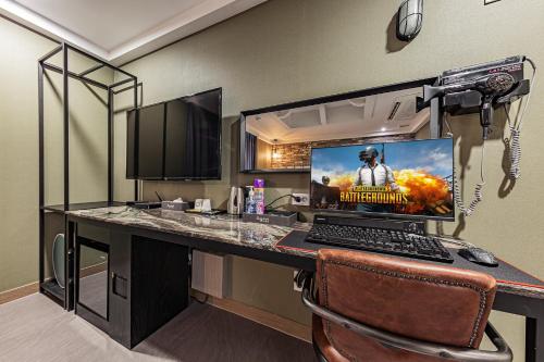 a room with a desk with a laptop computer on it at Hotel Soseol Smith in Cheonan