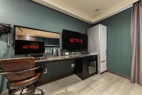 a reception desk with a netflix sign on a green wall at Hotel Soseol Smith in Cheonan