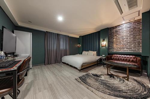 a hotel room with a bed and a couch at Hotel Soseol Smith in Cheonan