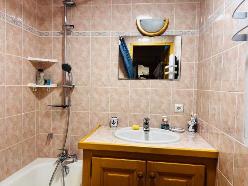 ein Badezimmer mit einem Waschbecken, einer Badewanne und einem Spiegel in der Unterkunft Appartement Les Saisies, 2 pièces, 6 personnes - FR-1-293-399 in Hauteluce