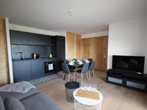 un salon avec une table et une cuisine dans l'établissement Les Saisies - Appartement 6 pers, WiFi, Parking, équipements neufs - FR-1-293-398, à Hauteluce