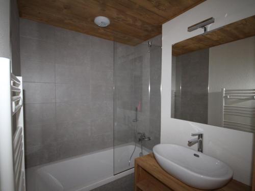 une salle de bain avec un lavabo blanc et une douche dans l'établissement Les Saisies - Appartement 6 pers, WiFi, Parking, équipements neufs - FR-1-293-398, à Hauteluce