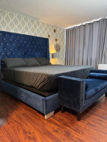 a bedroom with a blue bed and a blue couch at The Village Inn Hotel in Milwaukee