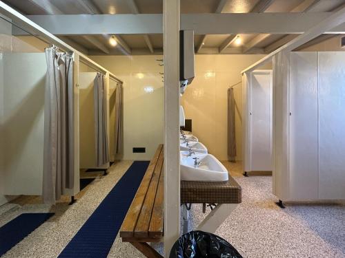 a bathroom with three sinks and a row of stalls at The Crossing Lodge & Backpackers in National Park