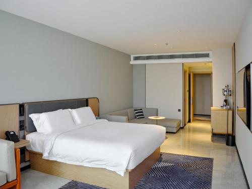 1 dormitorio con 1 cama y sala de estar en CitiGo HOTEL - 越南平阳新渊欢阁酒店 