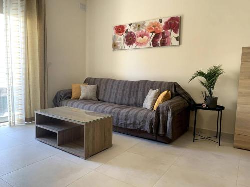 a living room with a couch and a coffee table at Cara Flats By Homely in Mellieħa