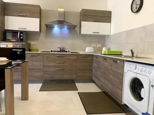 a kitchen with a washer and a dishwasher at Cara Flats By Homely in Mellieħa