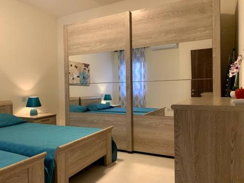 a bedroom with two beds and a large mirror at Cara Flats By Homely in Mellieħa