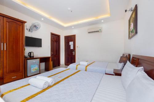 a hotel room with two beds and a television at Diamond Sea Hotel in Vung Tau