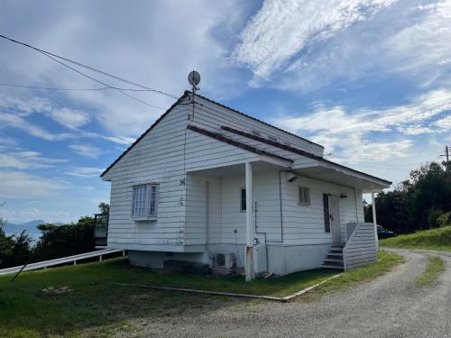 a small white house on the side of a road at GORORI in Tonosho