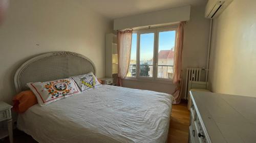 ein Schlafzimmer mit einem Bett und einem großen Fenster in der Unterkunft 3 Pieces Agreable, Confortable in Cannes