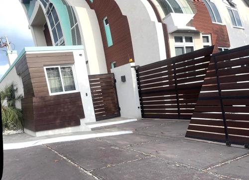 a wooden fence in front of a house at LIGUANEA -ONE BEDROOM OASIS near US EMBASSY in Barbican