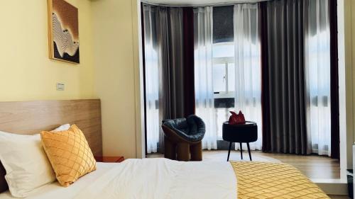 a bedroom with a bed and a chair and a window at 玥熙民宿 in Jinhu
