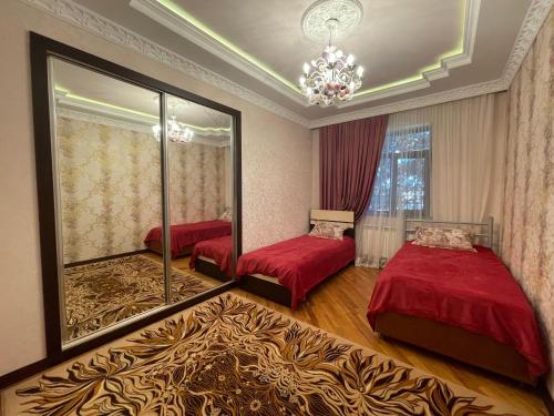 a bedroom with two beds and a mirror at Green Garden Shuvelan in Baku