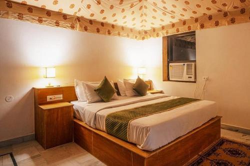 Jaisalmer Unique Desert Camp في Sām: غرفة نوم بسرير كبير في غرفة