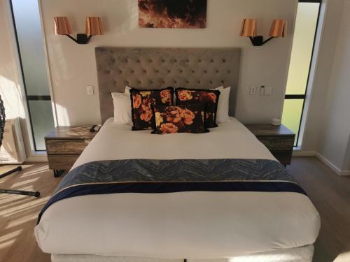 a bedroom with a large white bed with pillows at Luxury Harbour view in Dunedin