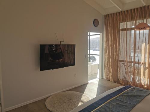 a white room with a bed and a large window at Luxury Harbour view in Dunedin