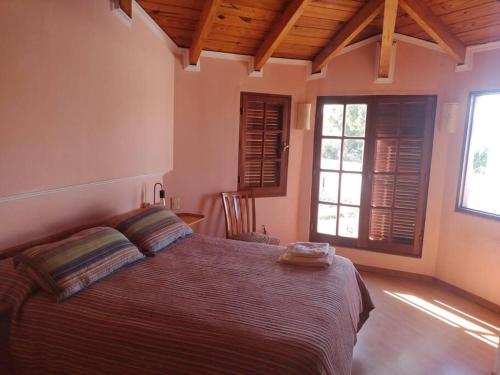 a bedroom with a large bed and two windows at comodidad y tranquilidad in Jesús María