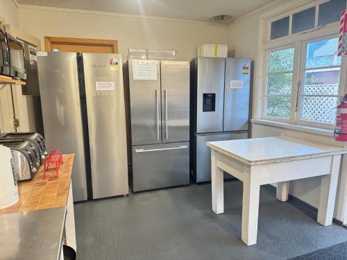 a kitchen with two refrigerators and a table in it at The Crossing Lodge & Backpackers in National Park