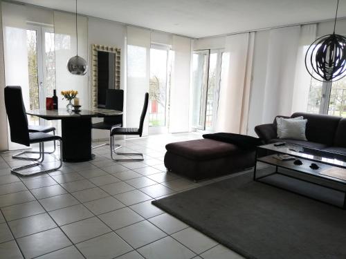ein Wohnzimmer mit einem Sofa und einem Tisch in der Unterkunft Schicke 2 Zimmer Wohnung nah an Stuttgart Messe Flughafen in Ostfildern