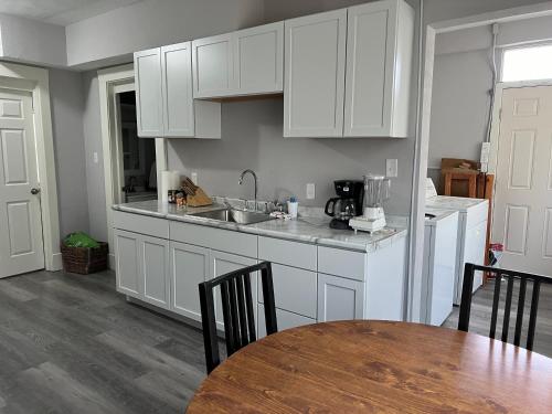 a kitchen with white cabinets and a table and a sink at House w Separate 4 Private Bedrooms in South Bend