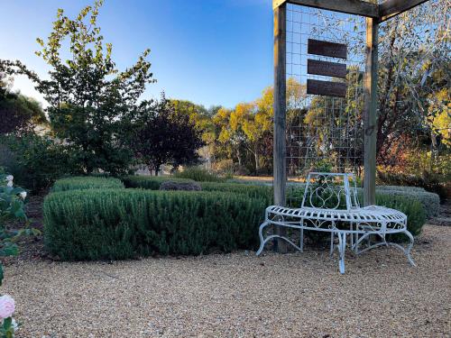 a bench sitting in the middle of a garden at Barossa Garden Homestay in Williamstown