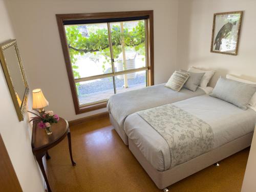 a bedroom with a bed and a large window at Barossa Garden Homestay in Williamstown