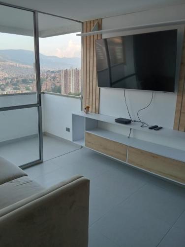 a living room with a flat screen tv and a couch at Apartamento en Edificio Puerto paraiso en Bello Antioquia in Bello