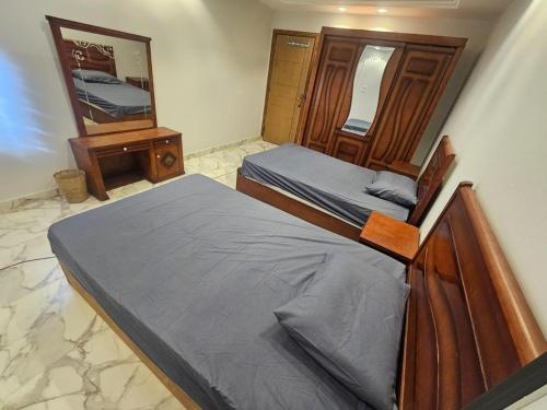 - une chambre avec 2 lits et un miroir dans l'établissement شقة مودرن للايجار اليومي والاسبوعي, à Mansoura