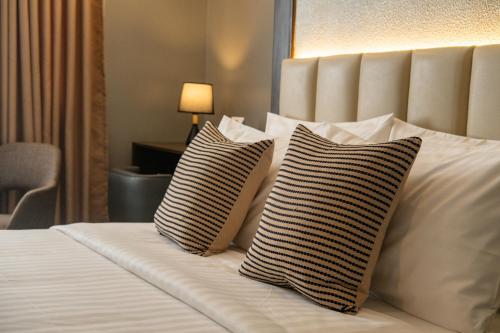 two pillows on a bed in a hotel room at Amber Hotel - Cebu in Cebu City
