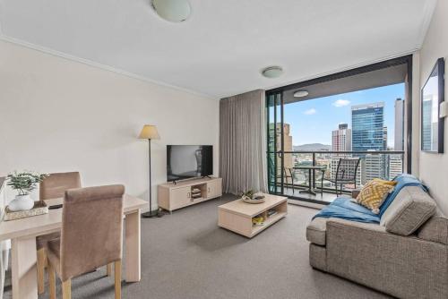 a living room with a couch and a desk and a window at City Centre! 1Bed/1Bath/Study/1Car/Balcony ~ CBD in Brisbane