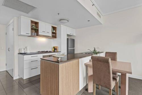 a kitchen with white cabinets and a wooden counter top at City Centre! 1Bed/1Bath/Study/1Car/Balcony ~ CBD in Brisbane