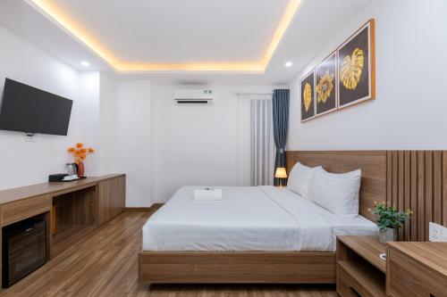 a hotel room with a bed and a flat screen tv at Diamond Sea Hotel in Vung Tau