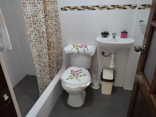 a bathroom with a toilet and a sink at Yaku Wasi in Leimebamba