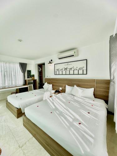 two beds in a hotel room with red flowers on them at Tuấn Ninh Hotel I in Con Dao
