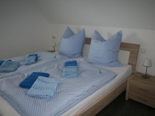 a bed with blue pillows and blue towels on it at Ostseebrandung - Haus Seepferdchen in Dranske