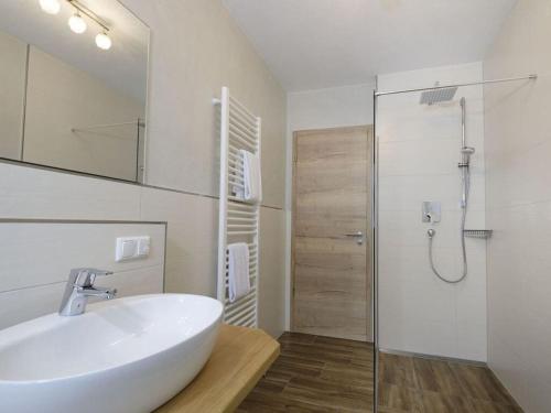 a white bathroom with a sink and a shower at Schachen Modern retreat in Garmisch-Partenkirchen