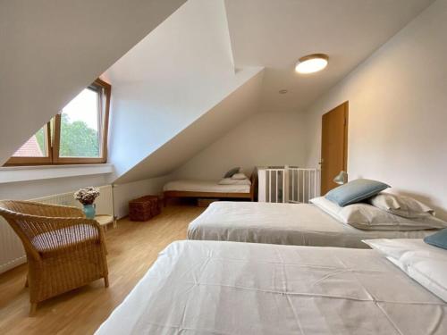 sypialnia na poddaszu z 2 łóżkami i schodami w obiekcie Dream vacation on Lake Ammersee w mieście Schondorf am Ammersee