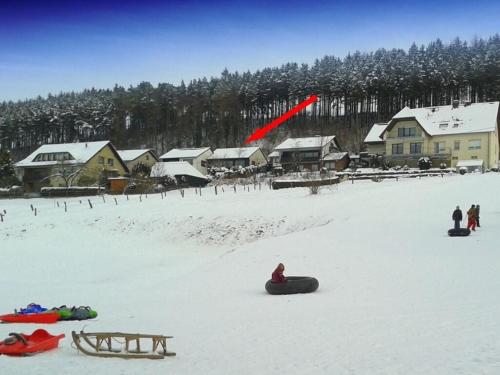 a red kite flying over a snow covered village at Holiday home Blumenhain in Bad Wünnenberg