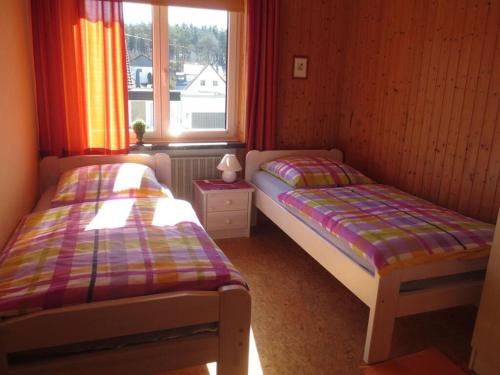 two beds in a small room with a window at Kläs Haus Eifelsonne 