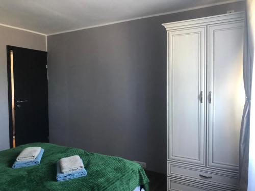a bedroom with a green bed and a white cabinet at Joy in Oradea