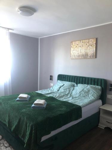 a bedroom with a bed with two towels on it at Joy in Oradea