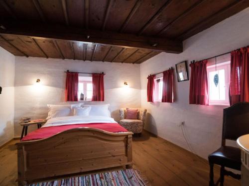 MAX in the Schusterhäusl في Achenmühle: غرفة نوم بسرير كبير مع ستائر حمراء