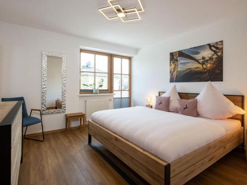 a bedroom with a bed and a desk and windows at Angerer - the holiday apartment 2 in Berchtesgaden