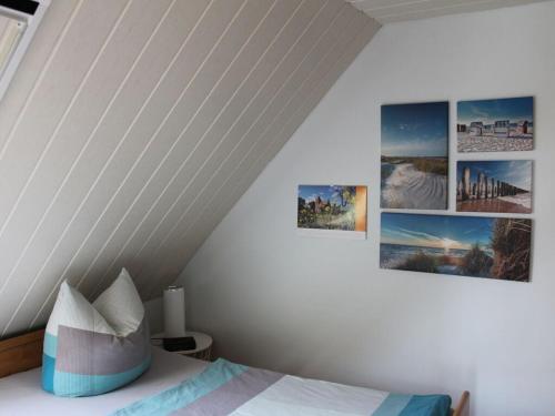 1 dormitorio con 4 cuadros en la pared en Holiday apartment by the forest en Kölpinsee