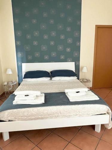 una camera da letto con un letto con due asciugamani sopra di Wanderlust Guesthouse a Lamezia Terme